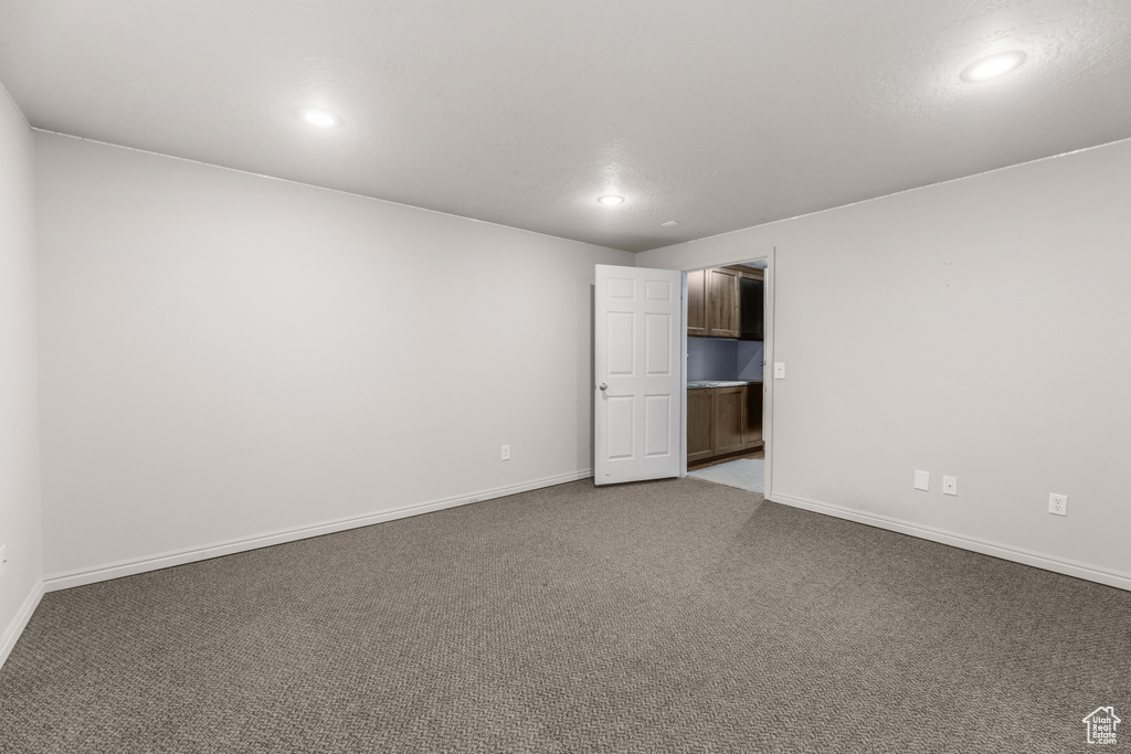 Carpeted empty room featuring baseboards and recessed lighting
