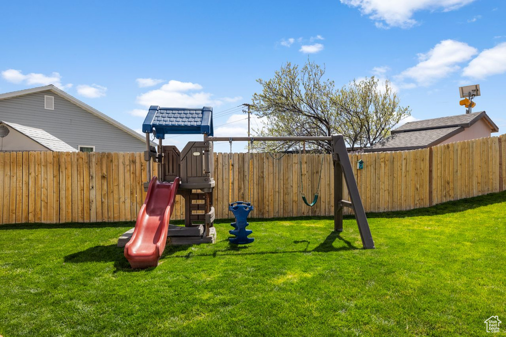 View of play area with a yard and a fenced backyard