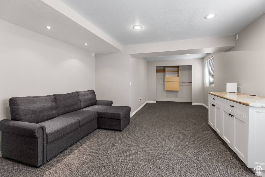 Living room featuring baseboards, recessed lighting, and dark colored carpet