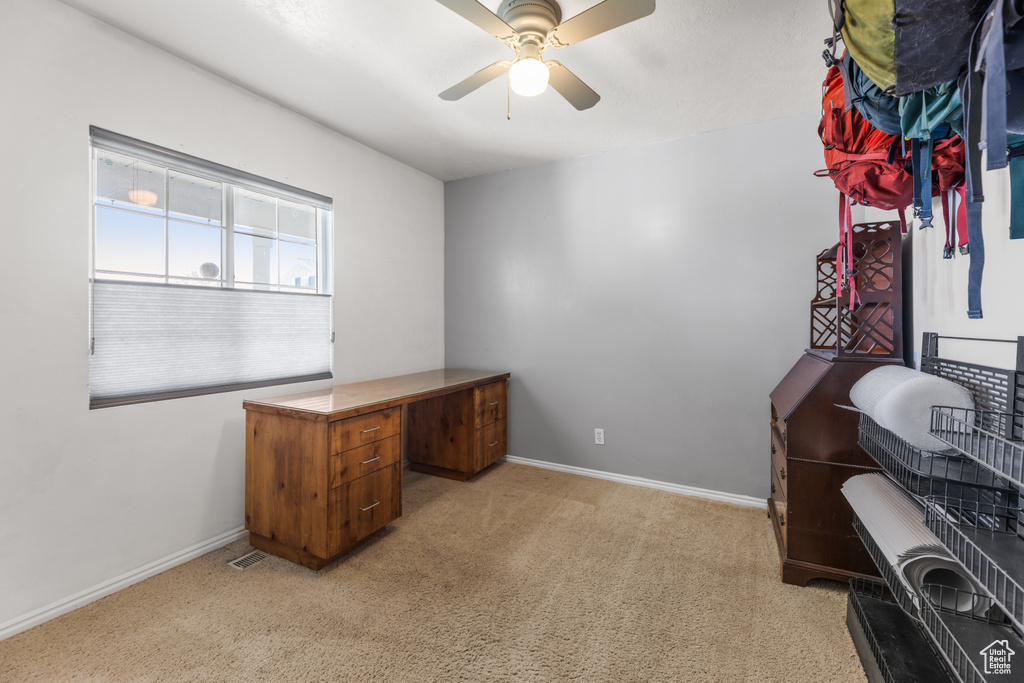 Office area with ceiling fan, light colored carpet, and baseboards