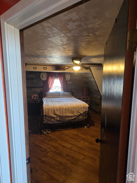 Bedroom featuring wood walls and wood finished floors