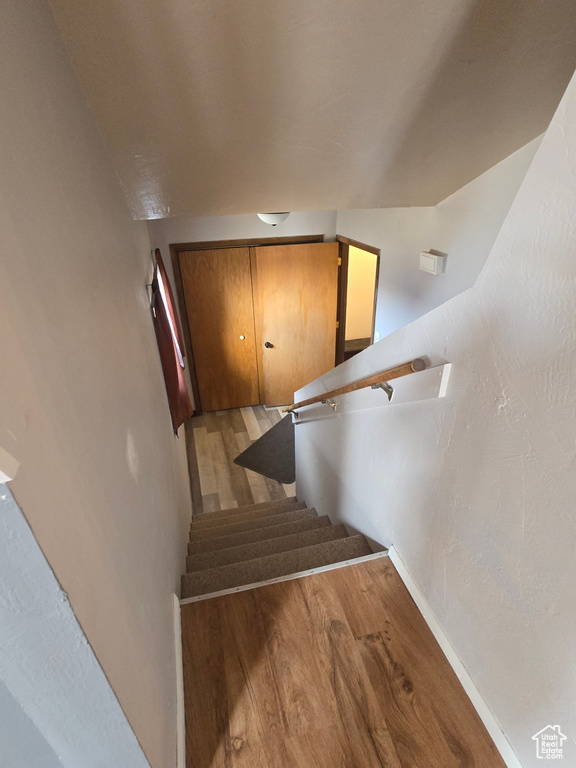 Stairs featuring wood finished floors