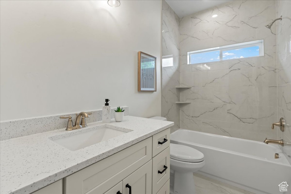 Bathroom with toilet, shower / bath combination, vanity, and marble finish flooring