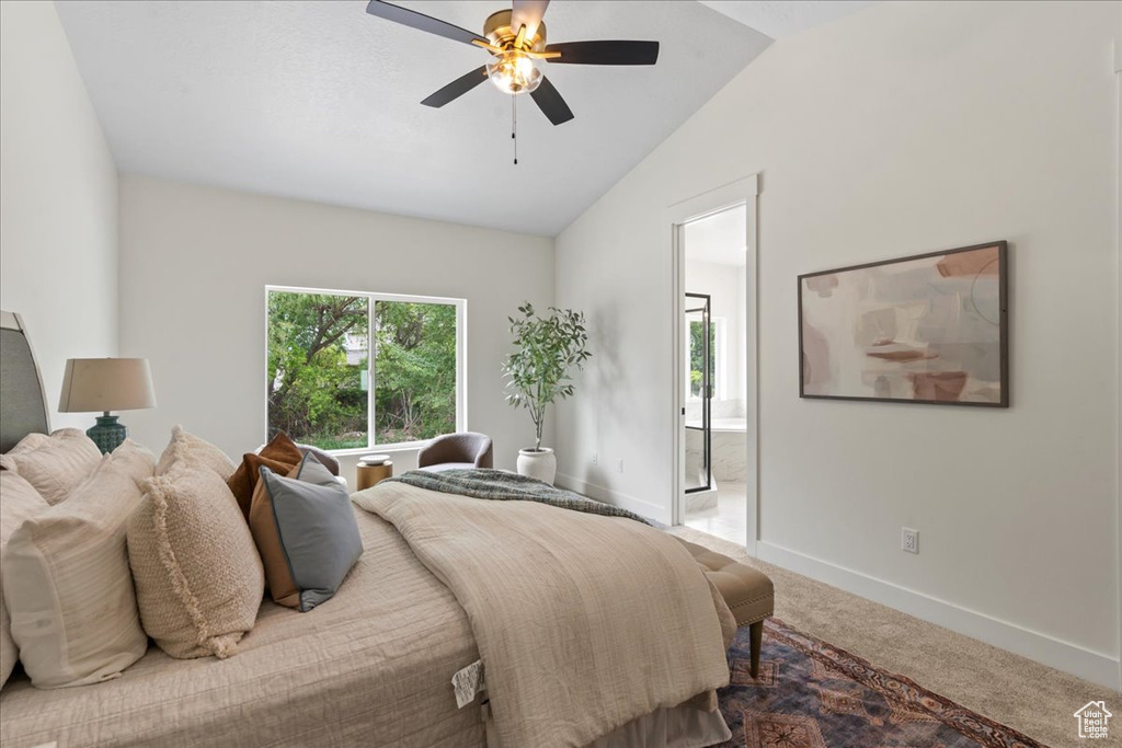 Carpeted bedroom featuring lofted ceiling, baseboards, ensuite bathroom, and ceiling fan