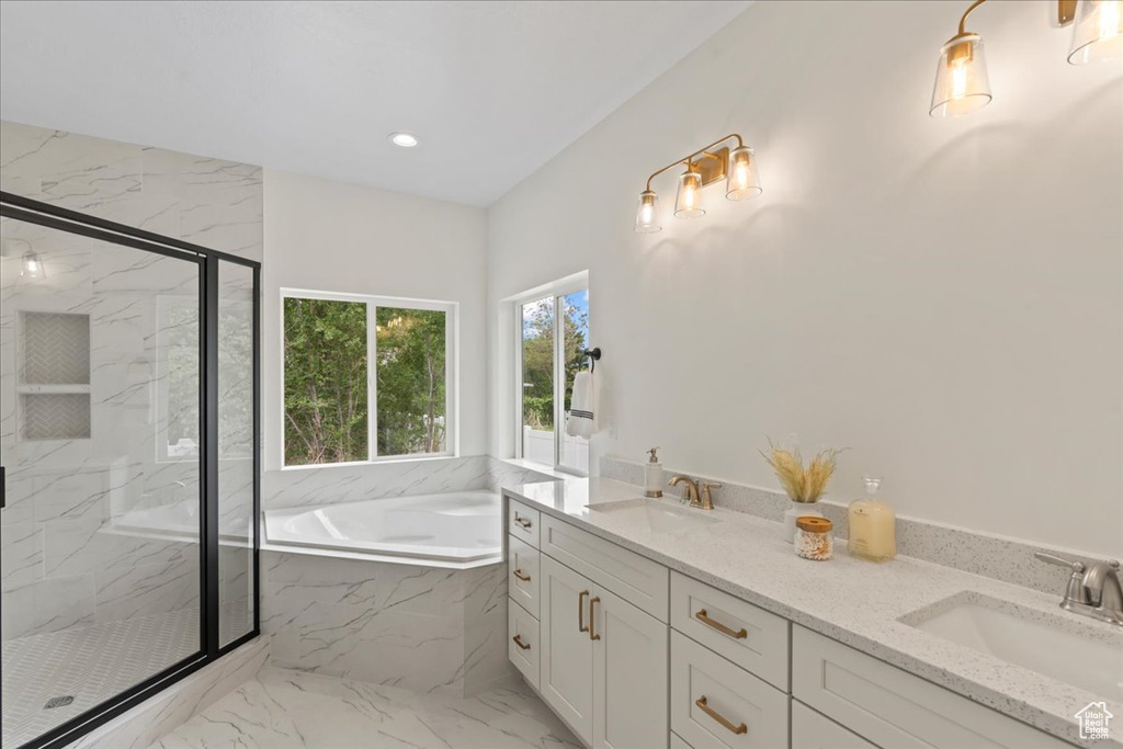 Full bathroom featuring marble look tile flooring, a marble finish shower, a bath, double vanity, and recessed lighting