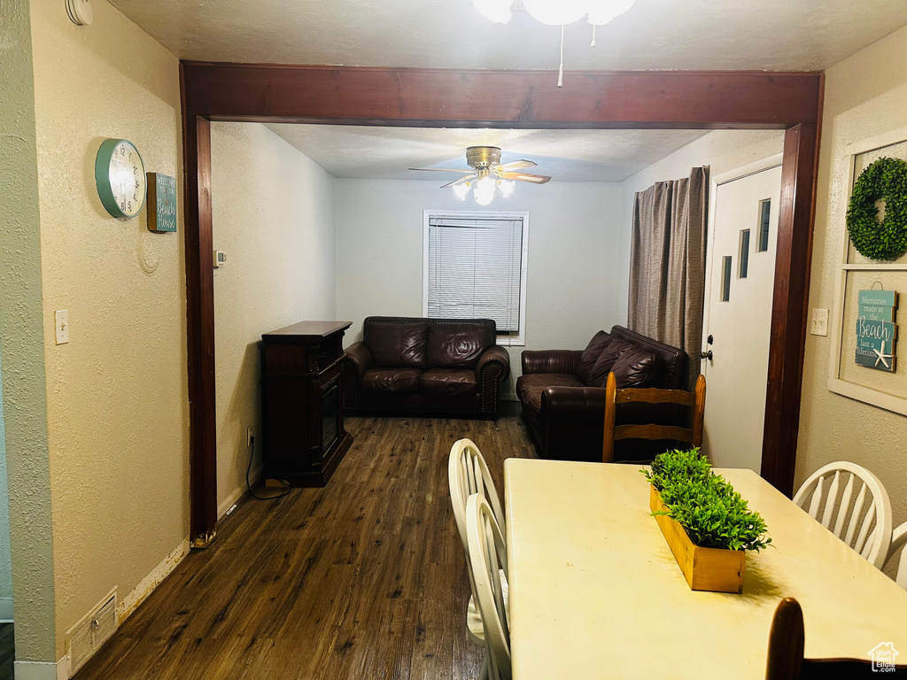 Dining room featuring a ceiling fan, dark wood-style floors, beamed ceiling, and baseboards