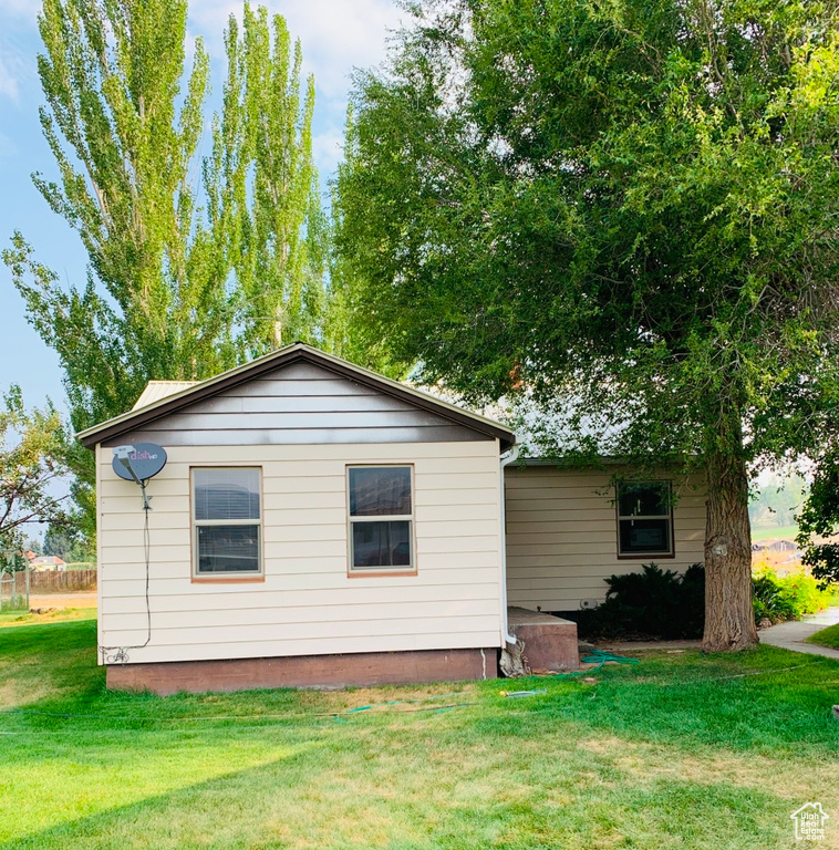 View of property exterior with a lawn