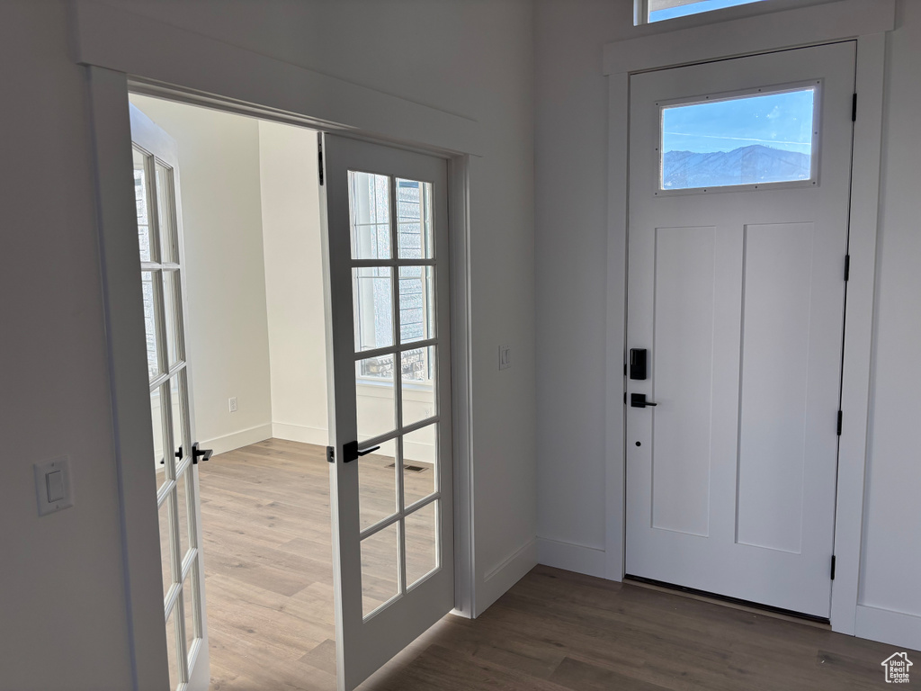 Entryway with baseboards and wood finished floors