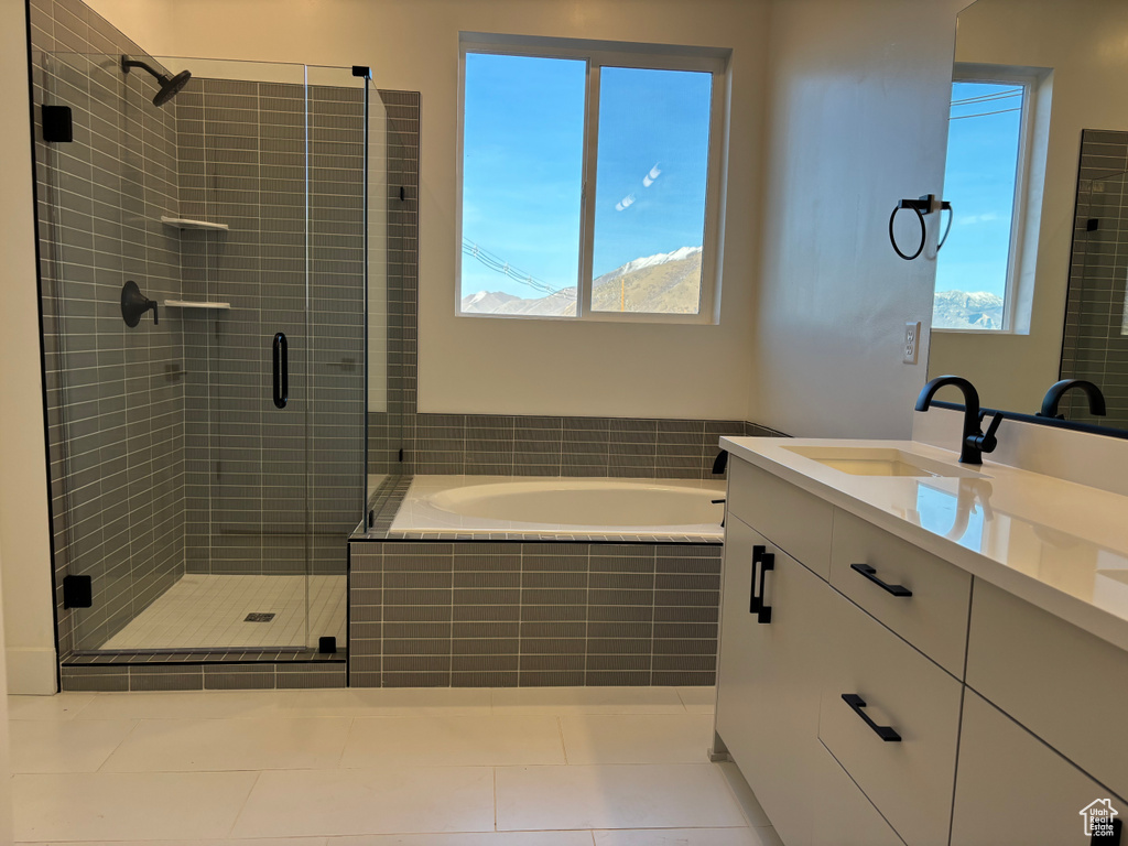 Bathroom featuring tile patterned flooring, plenty of natural light, a stall shower, and a garden tub