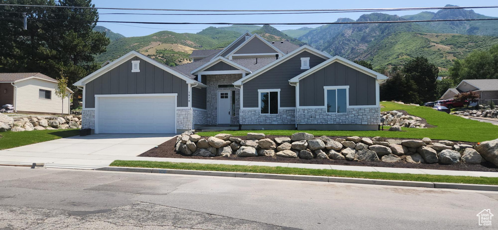 Craftsman house featuring board and batten siding, stone siding, and a mountain view