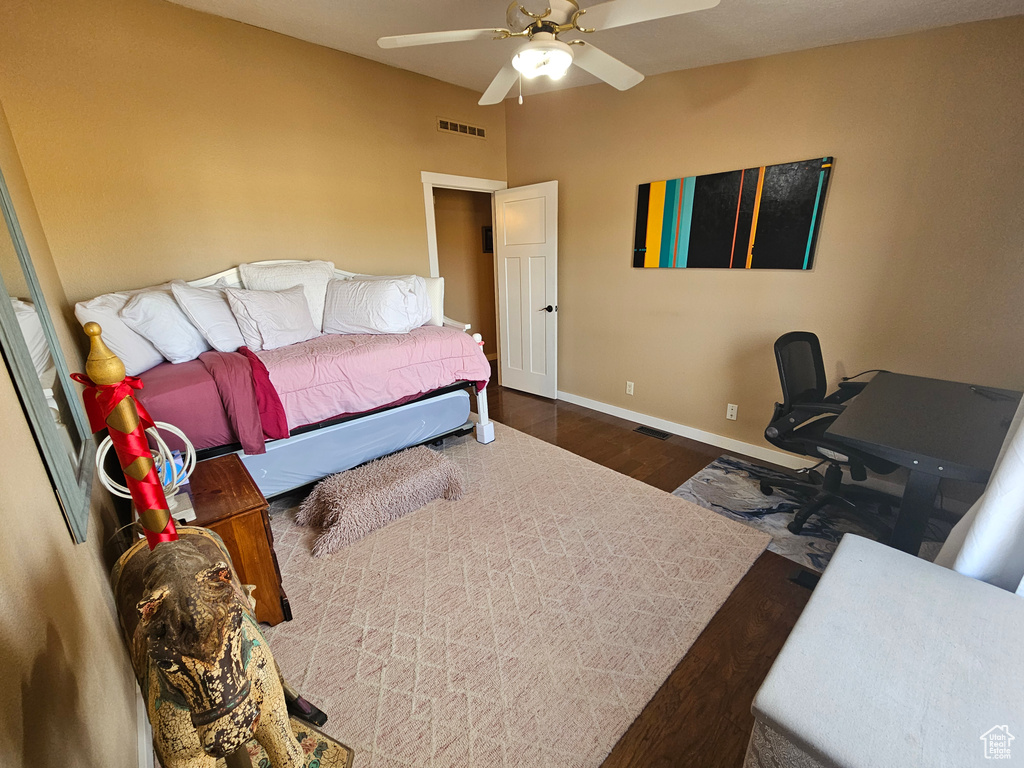 Bedroom featuring a ceiling fan, wood finished floors, baseboards, and visible vents