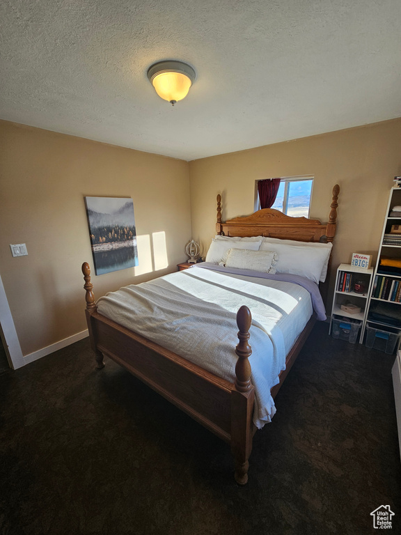 Carpeted bedroom with baseboards and a textured ceiling