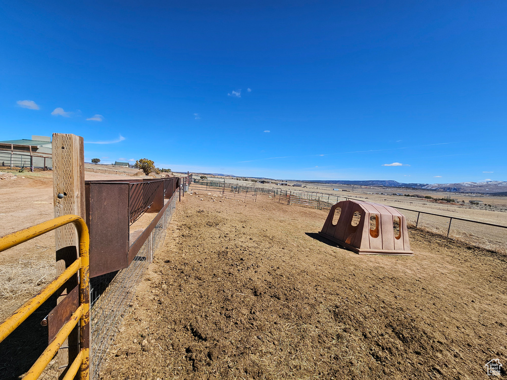 View of yard with fence and a rural view