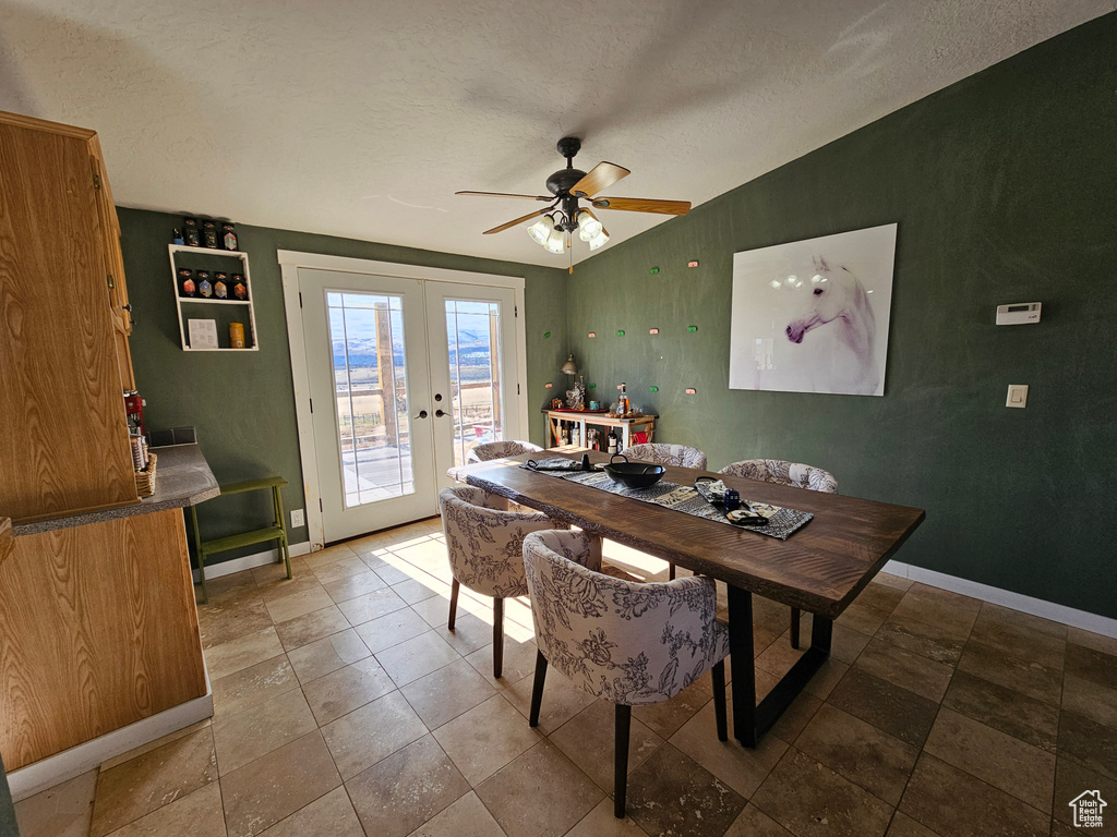 Dining area featuring french doors, baseboards, lofted ceiling, and ceiling fan