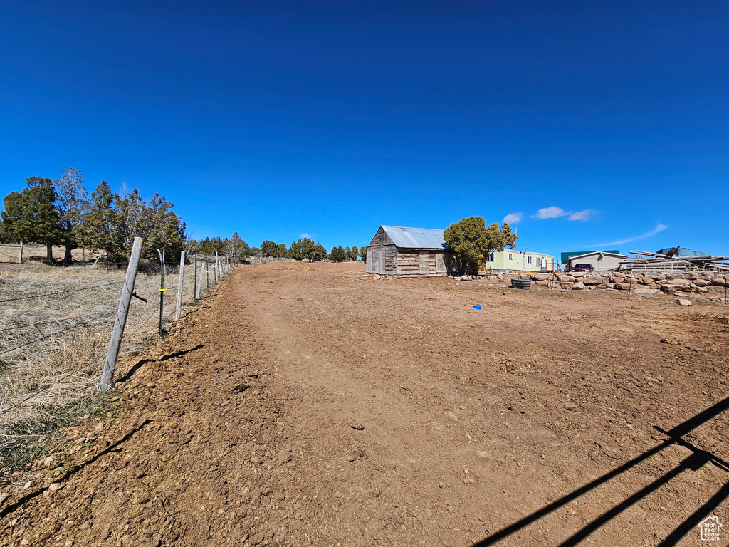 View of yard featuring an outbuilding and fence