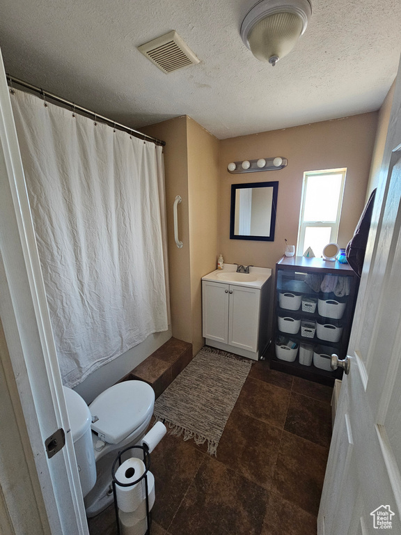 Full bath with a textured ceiling, visible vents, toilet, curtained shower, and vanity