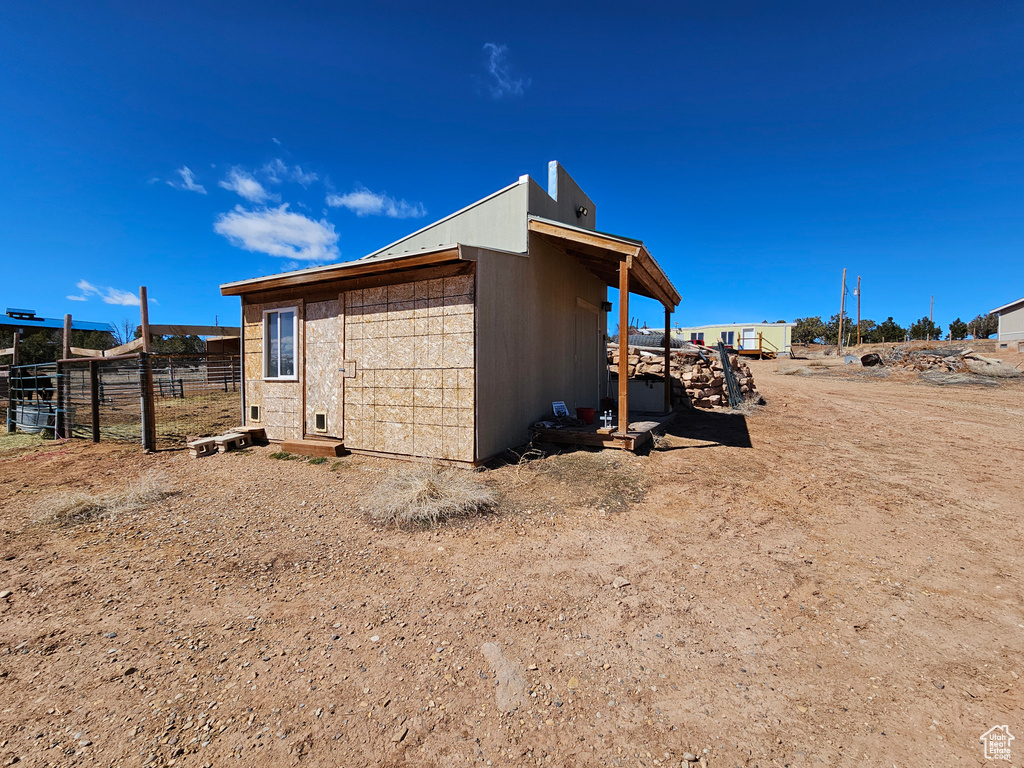 View of outdoor structure with an outbuilding and fence