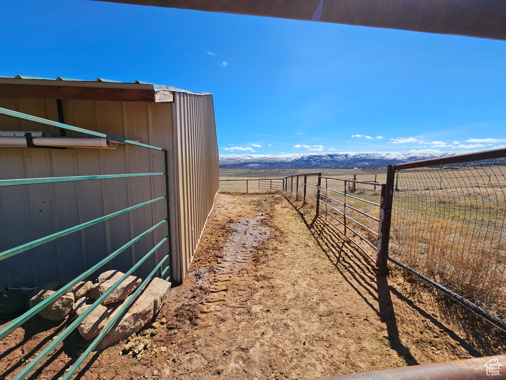 View of yard with a mountain view, fence, and a rural view