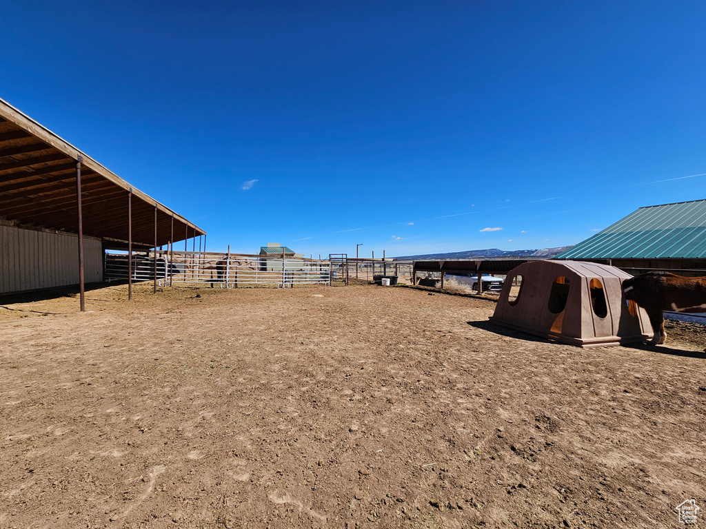 View of yard with a carport, an outdoor structure, and an exterior structure
