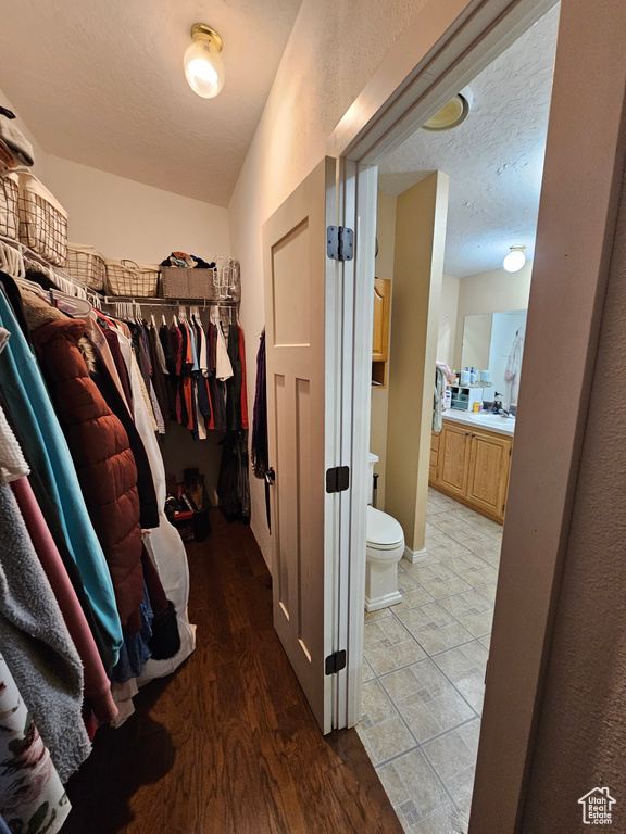 Spacious closet with light wood-style flooring and a sink
