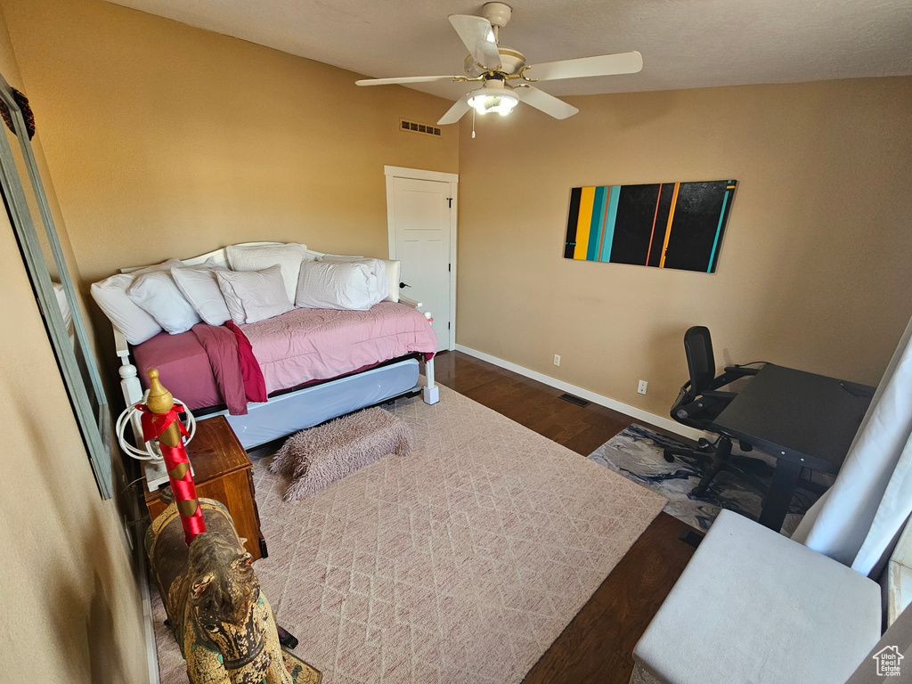 Bedroom featuring baseboards, visible vents, wood finished floors, and a ceiling fan