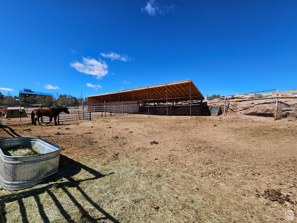 View of yard with a rural view, an outdoor structure, and an exterior structure