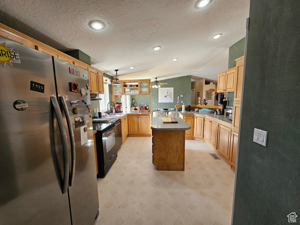 Kitchen featuring lofted ceiling, visible vents, freestanding refrigerator, a peninsula, and light floors
