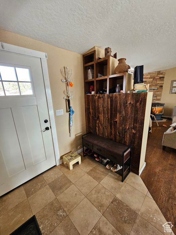 Entryway with baseboards and a textured ceiling