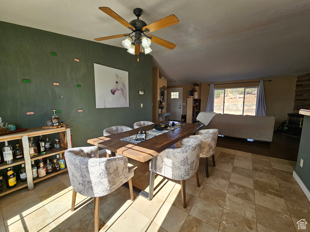 Dining room featuring baseboards, vaulted ceiling, and a ceiling fan