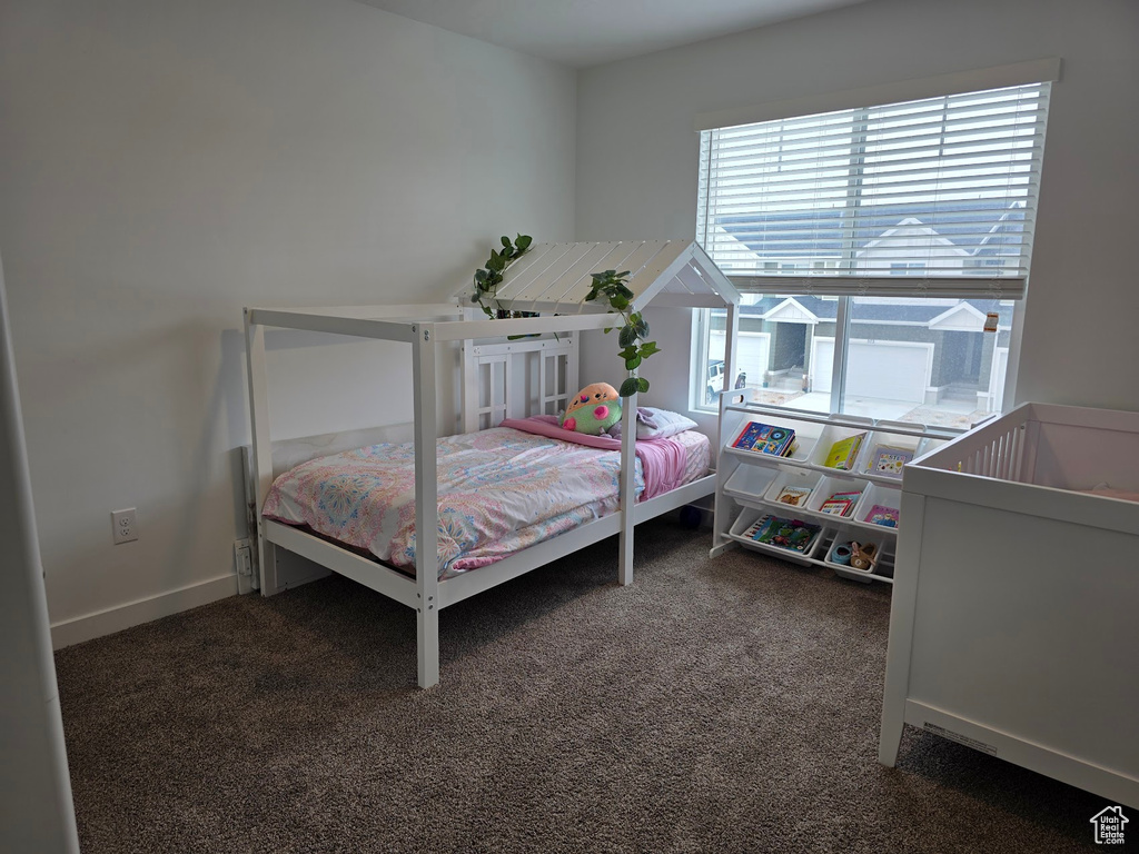 Bedroom featuring baseboards and dark colored carpet