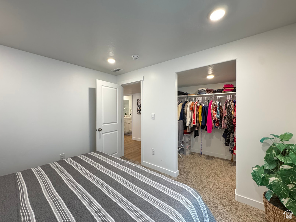Bedroom featuring baseboards, carpet floors, and a walk in closet