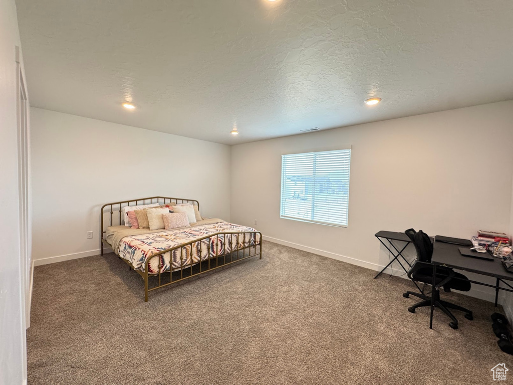 Bedroom with baseboards, carpet floors, a textured ceiling, and visible vents