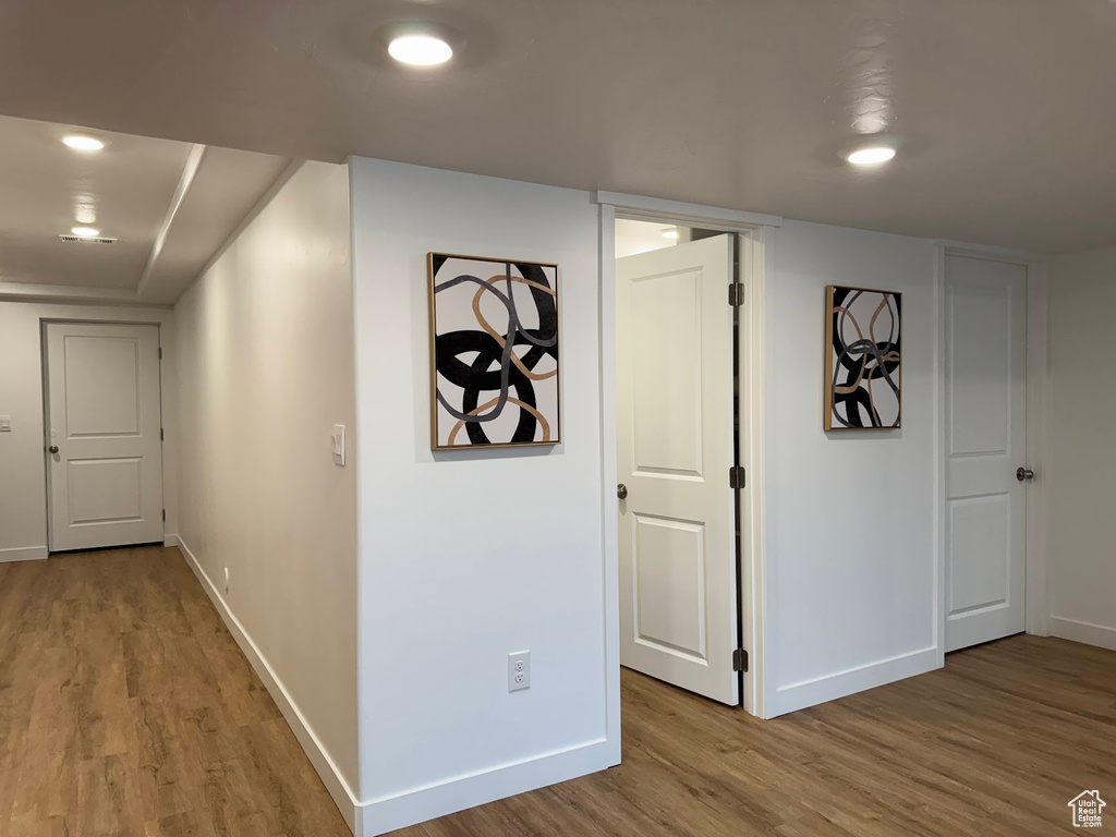 Corridor with baseboards, wood finished floors, and recessed lighting