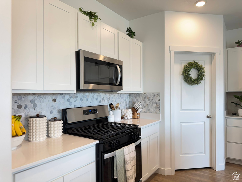 Kitchen featuring white cabinetry, light countertops, and appliances with stainless steel finishes