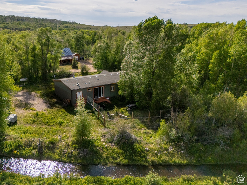 Aerial view of property and surrounding area with a forest
