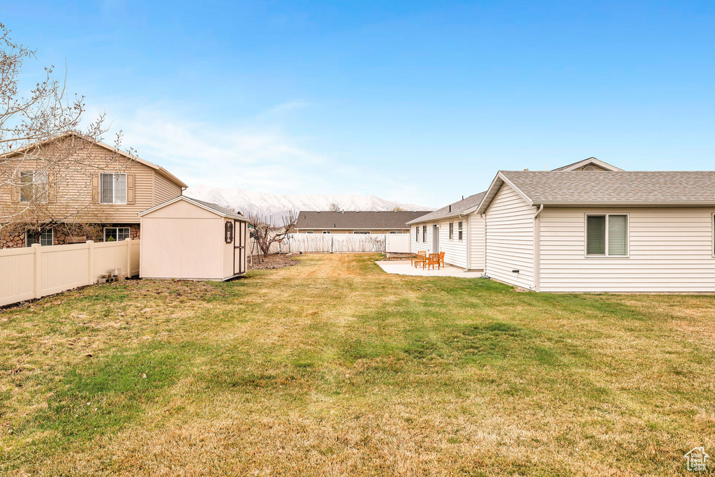 View of yard featuring a fenced backyard, an outbuilding, a storage shed, and a patio