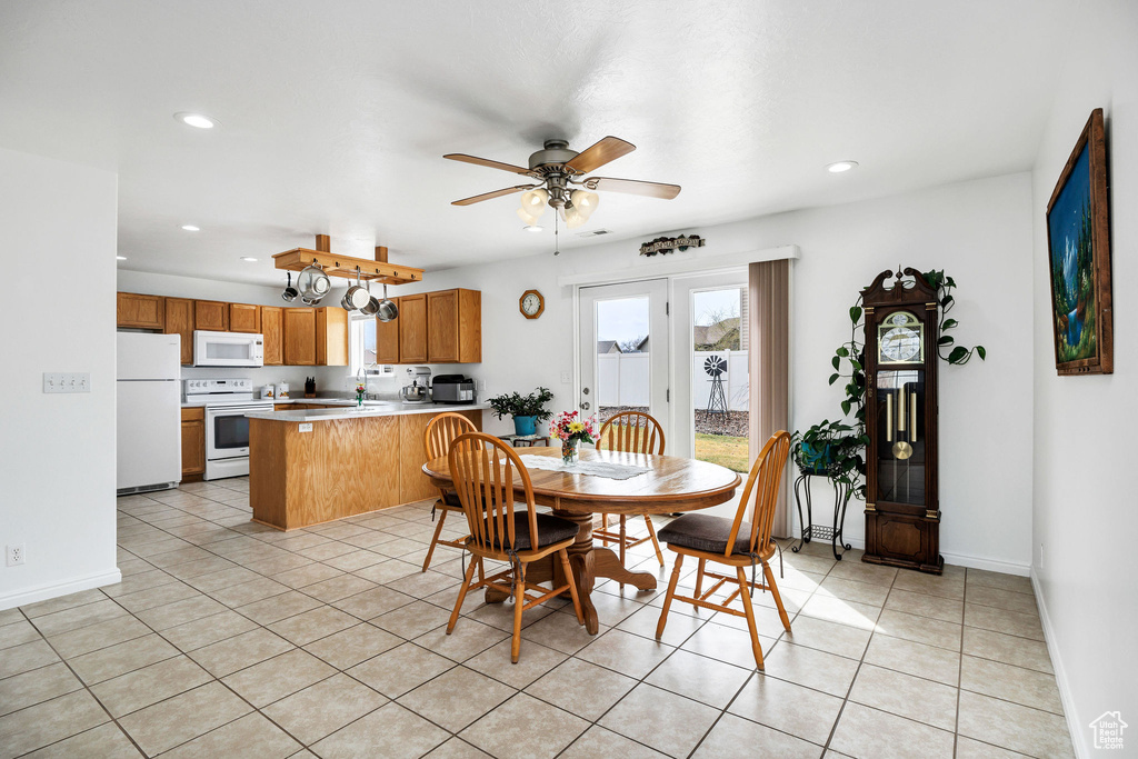 Dining room with a ceiling fan, light tile patterned flooring, and baseboards