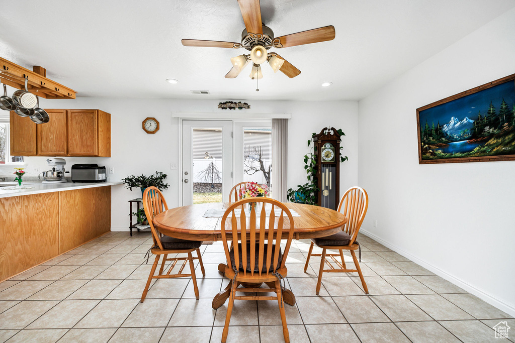Dining space featuring light tile patterned floors, visible vents, a healthy amount of sunlight, and ceiling fan