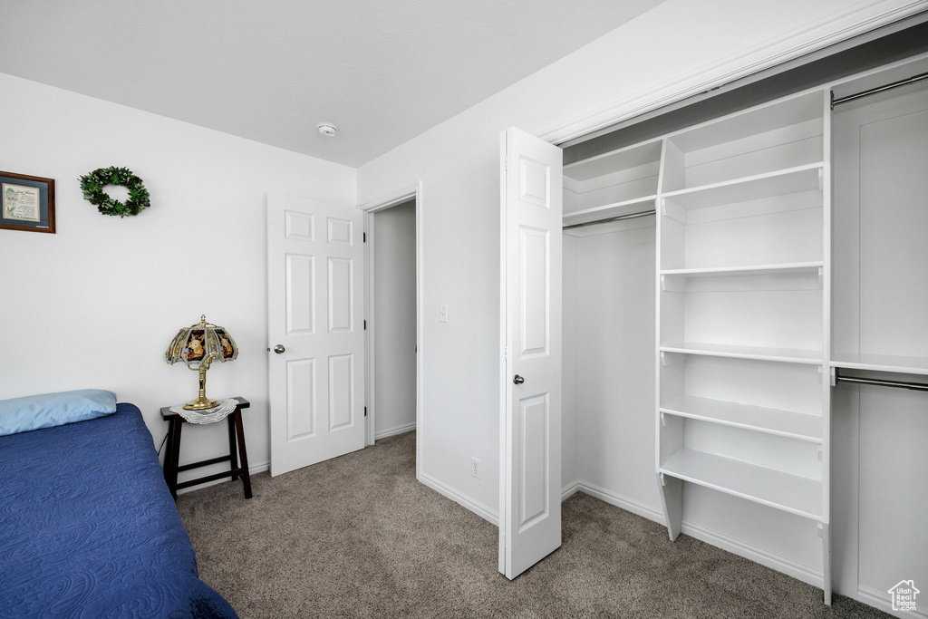 Unfurnished bedroom with a closet, carpet, and baseboards