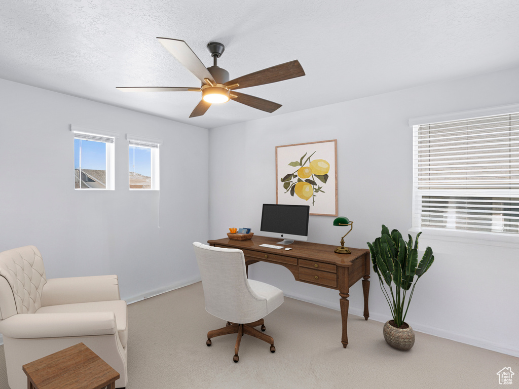 Home office with a ceiling fan, light colored carpet, and baseboards