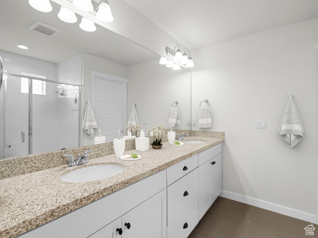 Bathroom with tile patterned flooring, baseboards, double vanity, and a stall shower