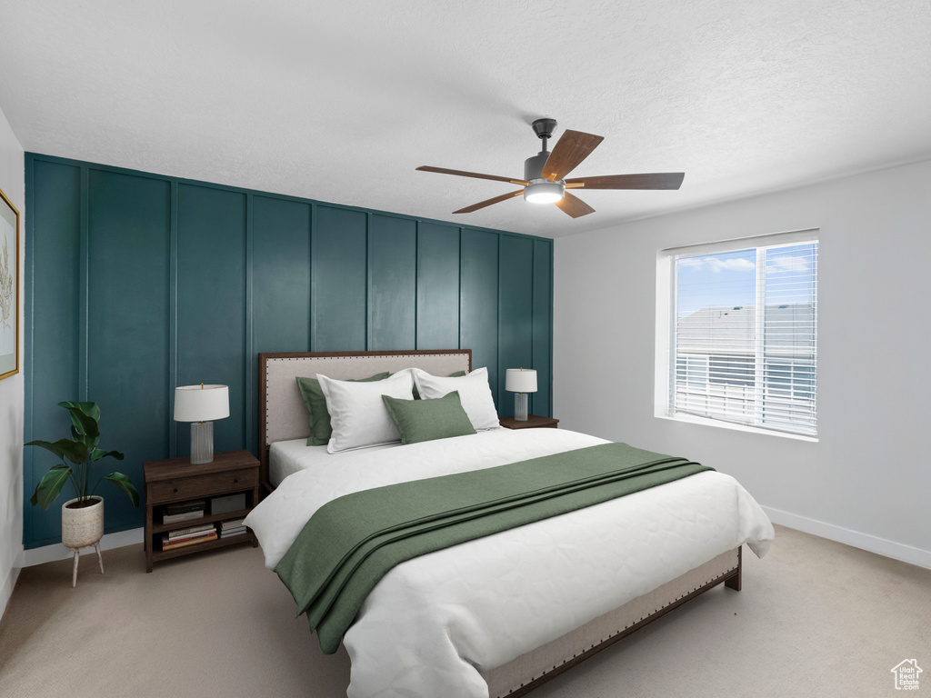 Bedroom featuring light colored carpet, baseboards, and a ceiling fan