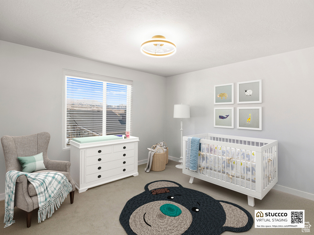 Carpeted bedroom with baseboards and a nursery area