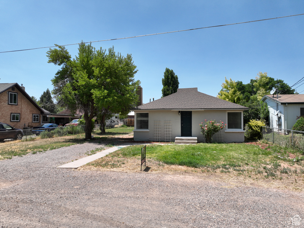 View of front of house with stucco siding and roof with shingles