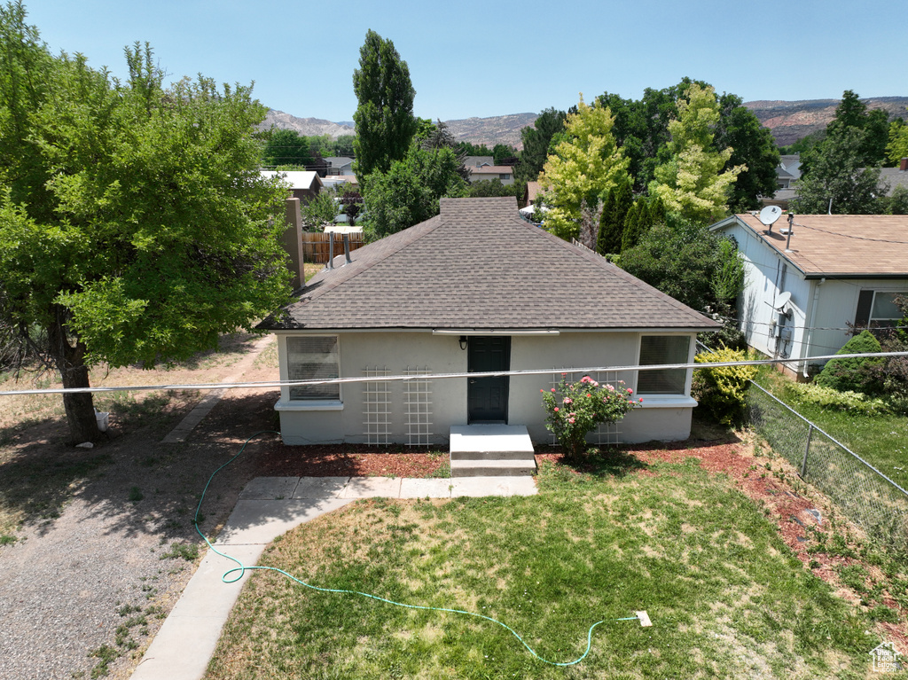 View of front of home with roof with shingles, stucco siding, and a mountain view