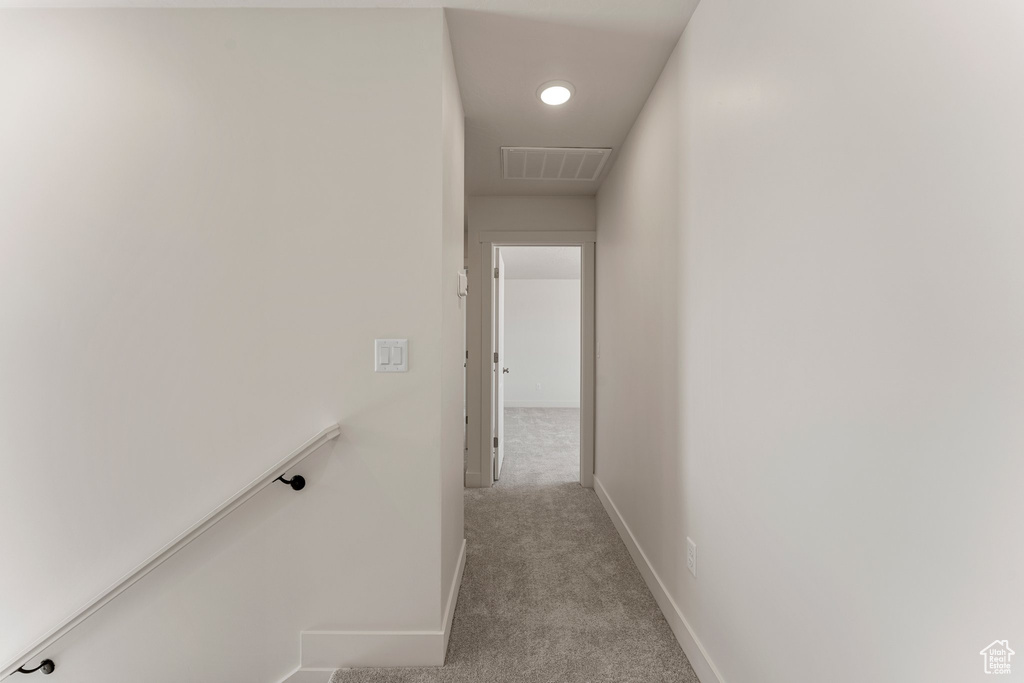 Corridor with light carpet and an upstairs landing