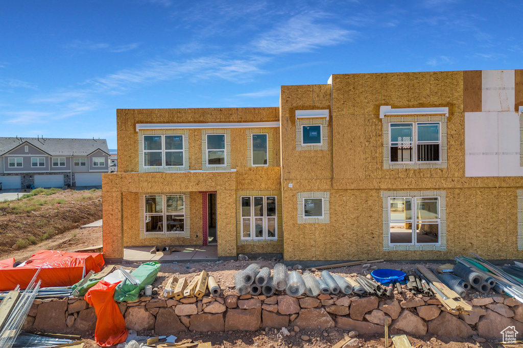 Rear view of house featuring stucco siding and a patio area