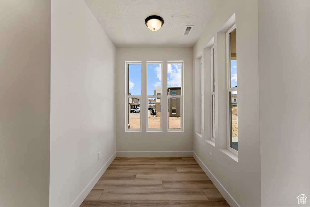 Empty room with light wood-style flooring and baseboards