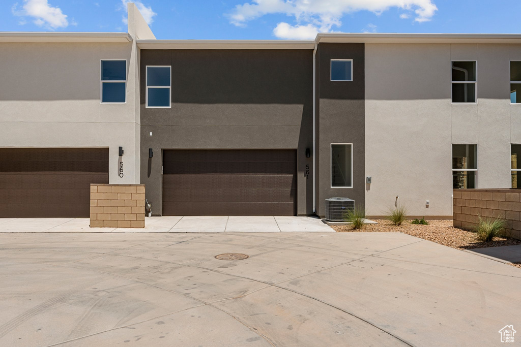 View of front of house with stucco siding, a garage, and driveway