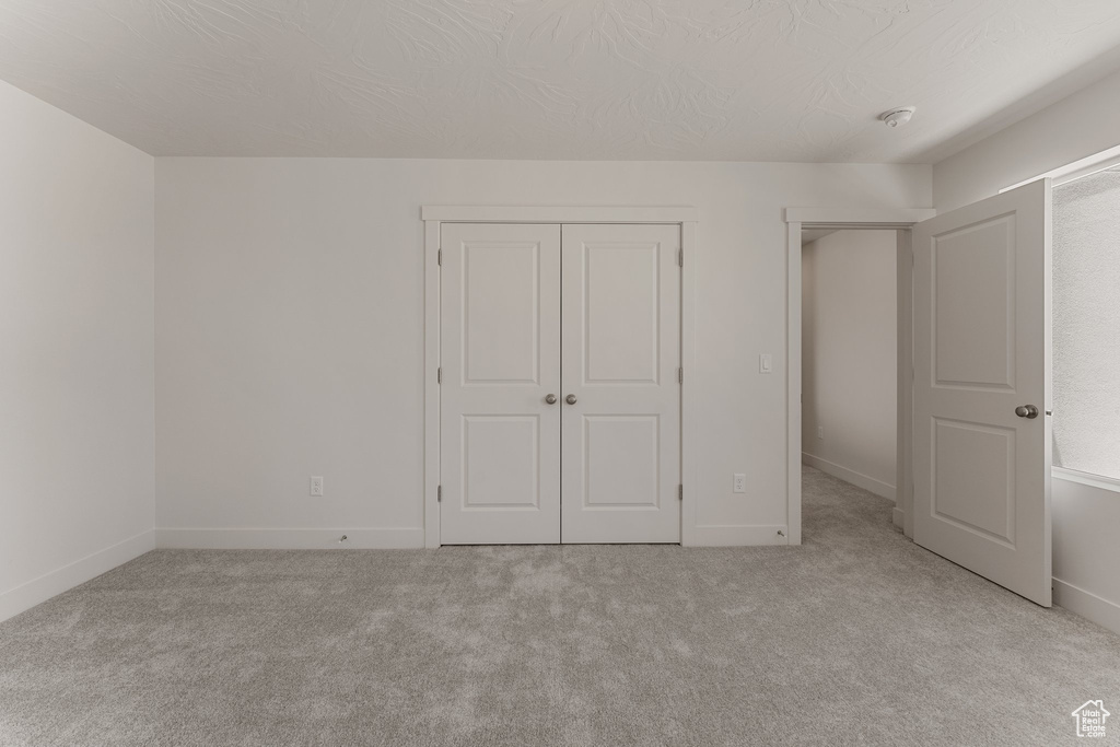 Unfurnished bedroom with carpet and a closet